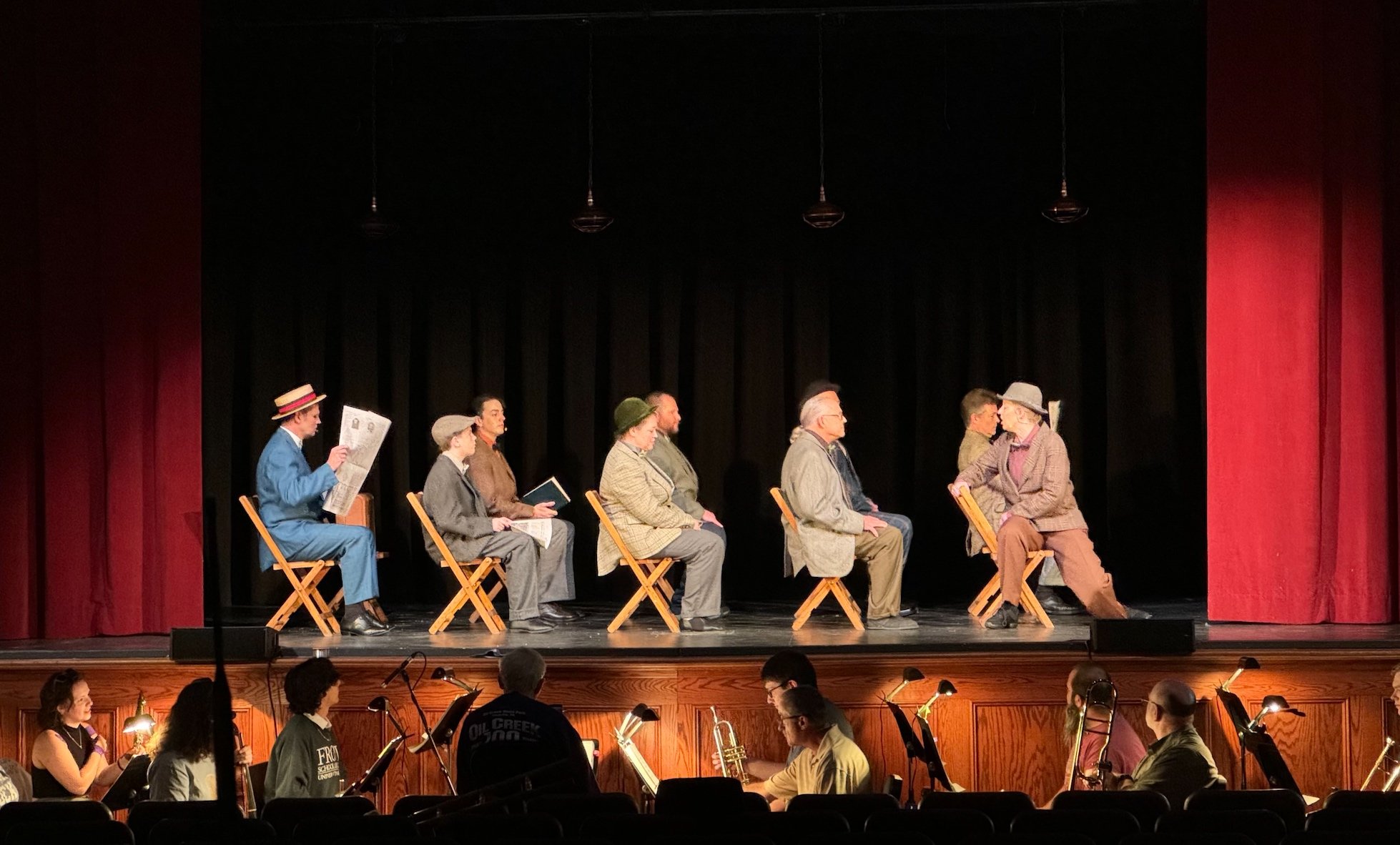 Business men sitting on chairs miming the motion of a train